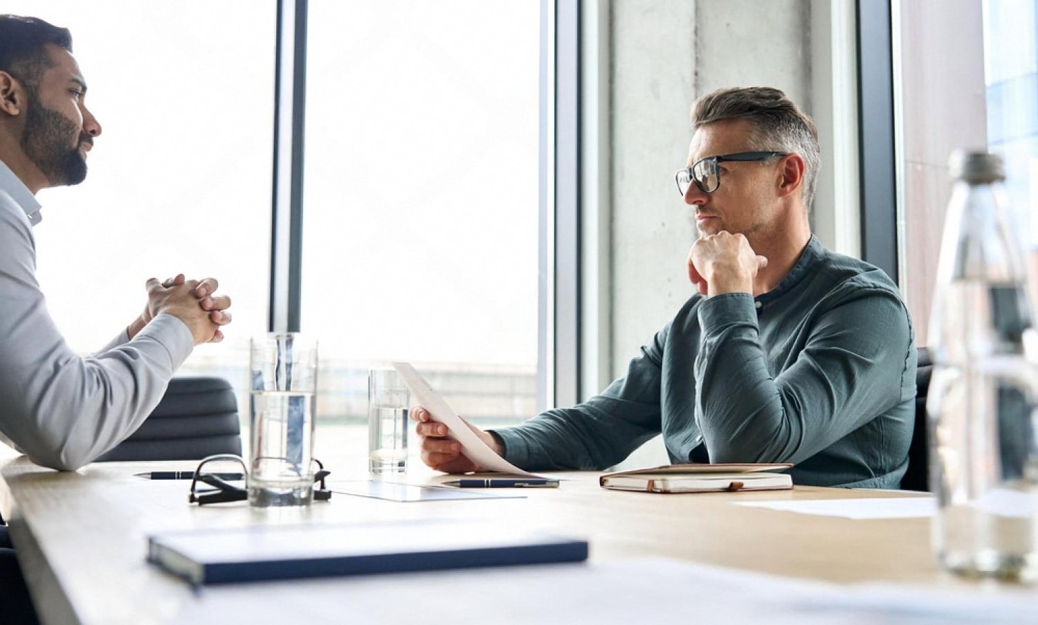 Manager reviewing an employee job description document during a performance discussion
